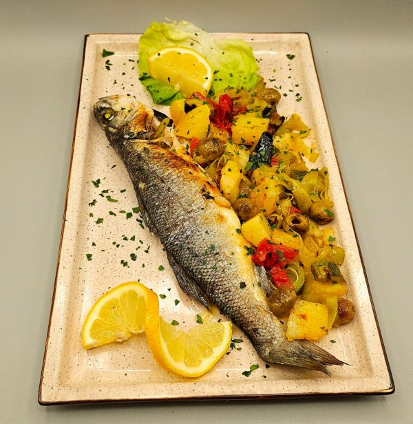 Spigola fresca cotta nel forno a legna con patate e verdure